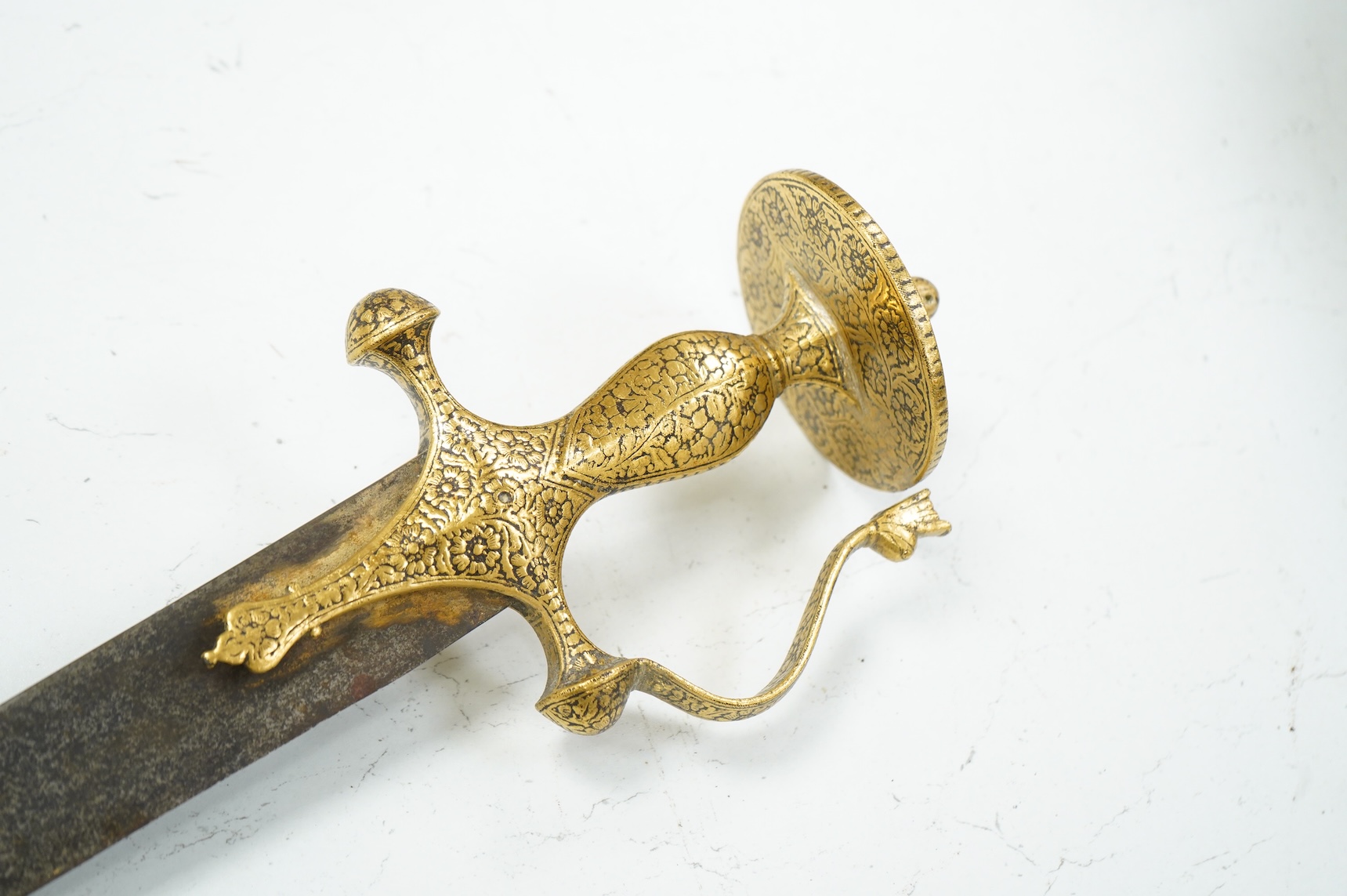 A good Indian sword tulwar, with 19th century broad curved single edge blade and iron hilt of conventional form entirely covered with flowering foliage